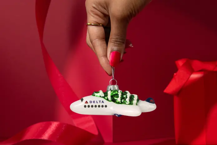 Soar into style with our Festive Delta Plane Ornament. Made of glass with a whimsical tree on top, make sure to snag one before it takes off!&nbsp;