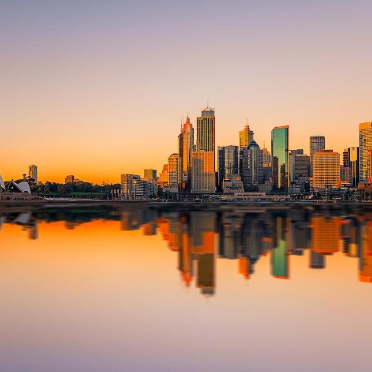 A view of downtown Sydney and the Opera House against a sunrise