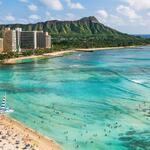 A skyline overlooking a beach and turquoise waters in Hawaii.