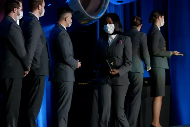 A Delta flight attendant walks off the stage with her new wings.