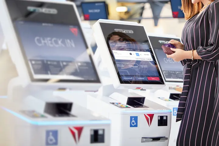 Customer checking in at a kiosk using their American Express card.