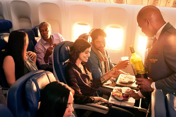 Delta flight attendant with Main Cabin customers.