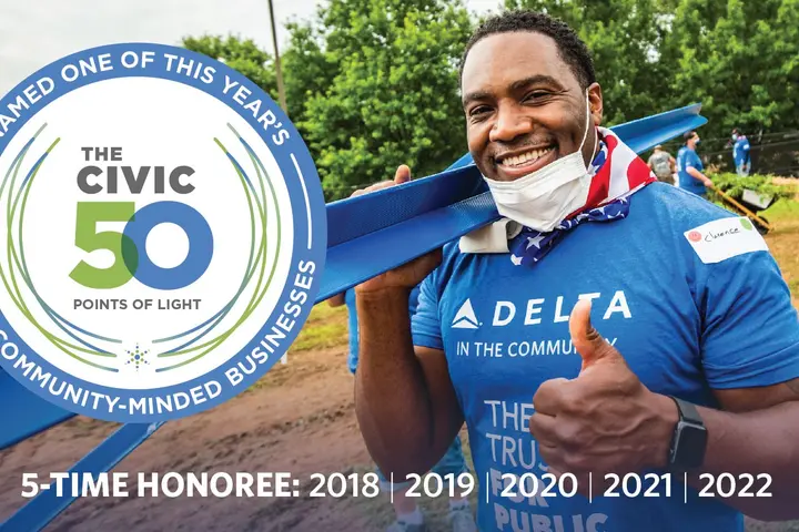 Photo featuring Delta volunteer with badge for winning Points of Light for fifth year in a row.
