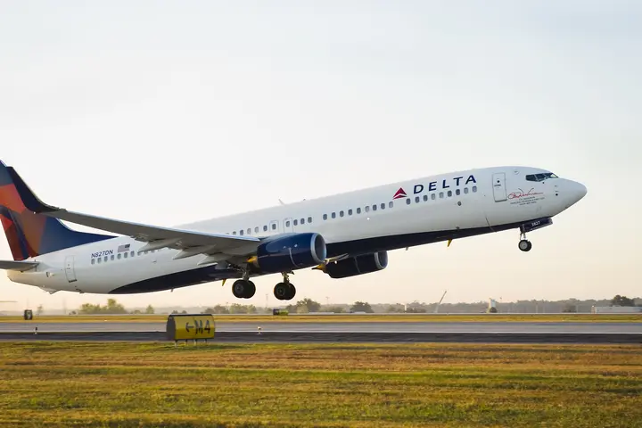 A 737-900 takes off into a clear sky.