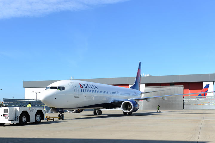 A straightforward shot of a 737-900 is captured on a runway.