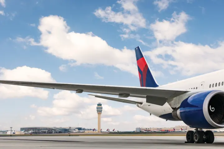 A dorsal view of Delta's Boeing 767-400 model sits on the Atlanta-based runway while a dynamic sky overlooks. 