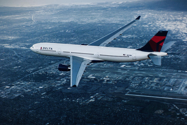 A330-300 in flight over city