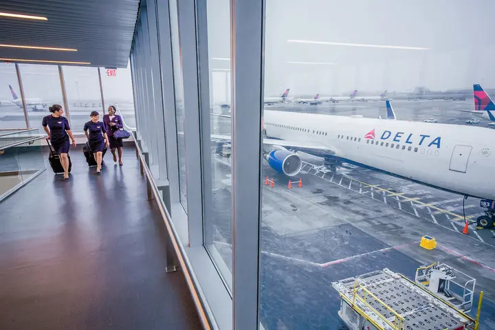 Delta flight attendants walk on a jetway at New York's John F. Kennedy International Airport.