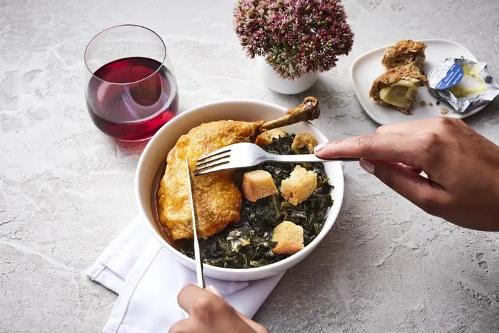Roasted chicken with smoked collard greens, a Delta first class meal offering, created by Chef Mashama Bailey