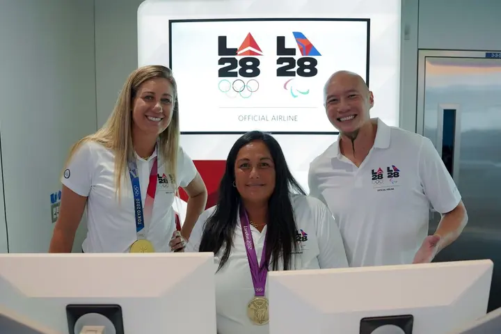 U.S. Olympians April Ross (left) and Brenda Villa (center), and U.S. Paralympian Jen Lee (right) pose for a photo at LAX near Delta's co-created LA28 logo on Sept. 29, 2022.