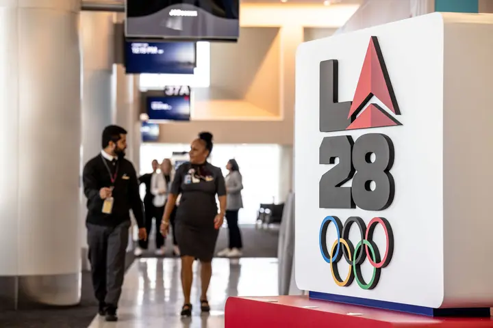 Delta employees walk through LAX near Delta's cocreated logo for LA28 on Sept. 29, 2022.