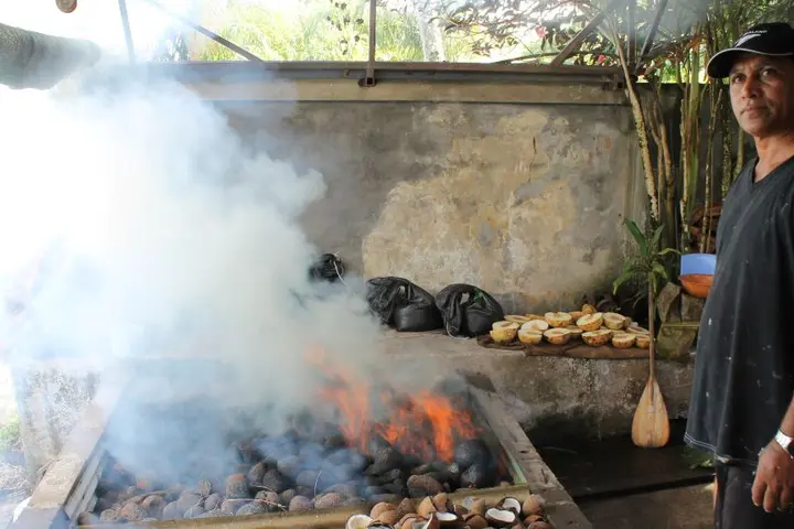 A Tahitian grilling food over an open flame