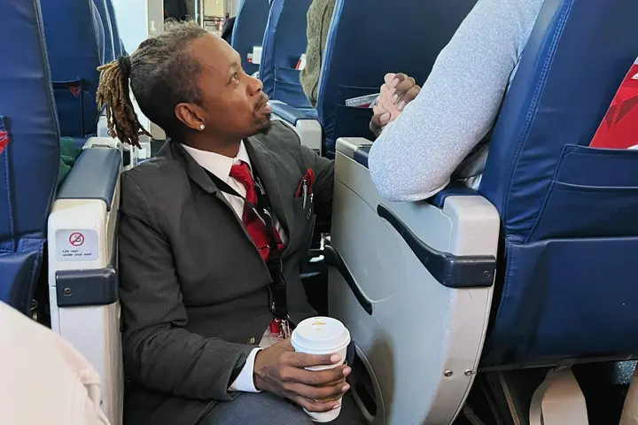 Endeavor Air flight attendant Floyd Dean-Shannon comforts a nervous customer during a Delta Connection flight from Charlotte to New York.