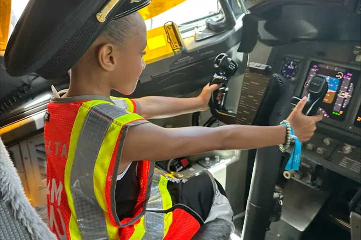 A child sits in the flight deck on an aircraft at San Juan Airport as part of a special initiative to inspire excitement about aviation.