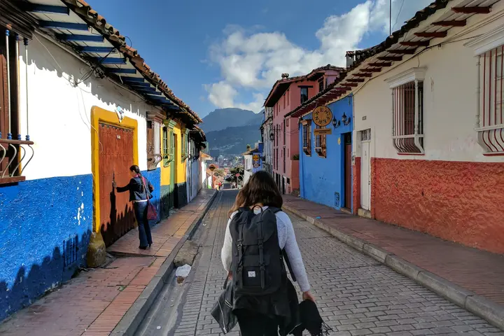 A girl wearing a backpack walks through La Candelaria, Bogota