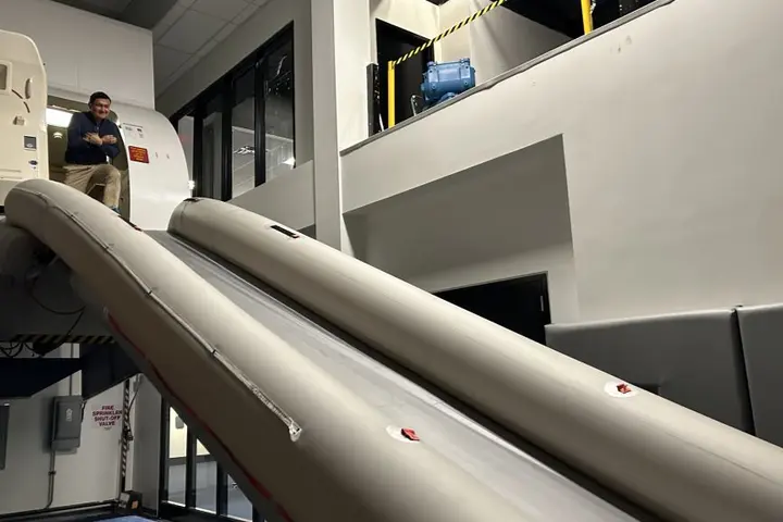 Todd O., Delta's most frequent flyer, prepares to take the plunge down the slide after an emergency flight simulator test. 
