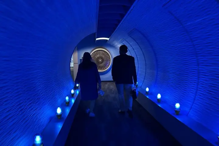 Todd O., Delta's most frequent flyer, and a Flight Museum employee walk through the breezeway before touring the Boeing 767 Spirit of Delta on the other side. 