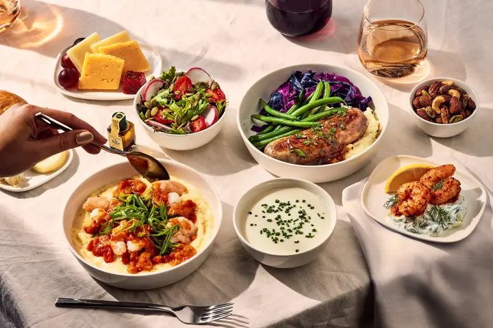 Delta One customers flying international on select flights may want to indulge in Chef Bailey’s creole shrimp with creamy grits and tomato gravy. Also available: Grilled bratwurst with braised red cabbage, herb mashed potatoes, green beans and a grain mustard demi-glace; cauliflower soup with a snipped-chives garnish; poached shrimp appetizer with cucumber yogurt sauce and lemon; and a side salad of mixed greens with radish, tomatoes and balsamic vinaigrette.