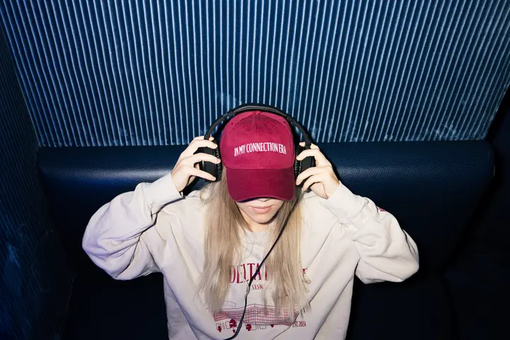 A SkyMiles member enjoys the Delta Sync Space at Delta's SXSW lounge while wearing exclusive Delta x SXSW merch. 