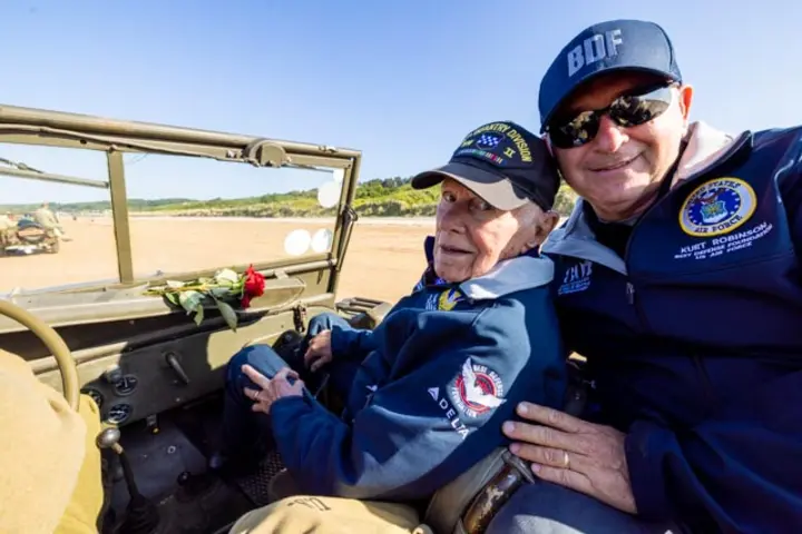 After signing countless autographs, the veterans enjoyed a ride on World War II-era vehicles to Omaha Beach, where they laid roses to remember comrades who lost their lives on those shores.
