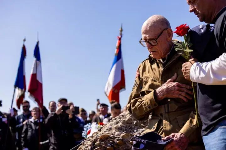 After signing countless autographs, the veterans enjoyed a ride on World War II-era vehicles to Omaha Beach, where they laid roses to remember comrades who lost their lives on those shores.