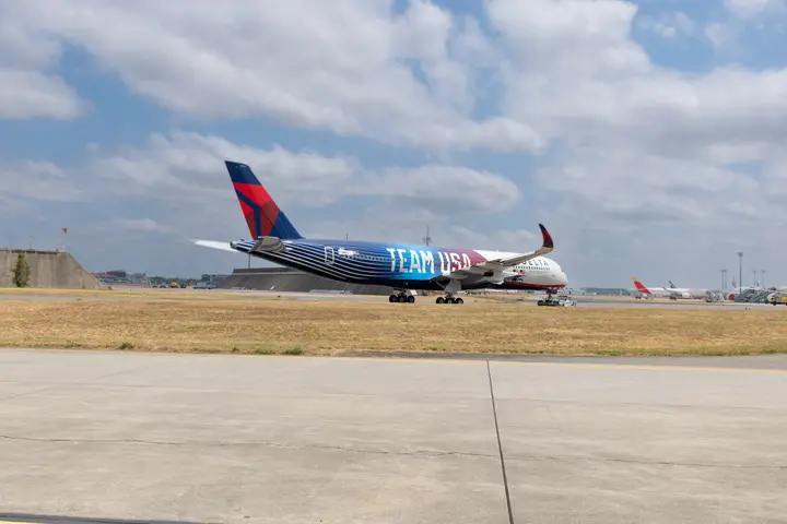 Delta airplane with Team USA livery taxing on runway.
