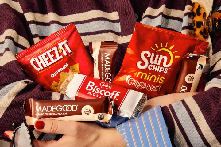 Someone holds an armful of snack served on Delta flights