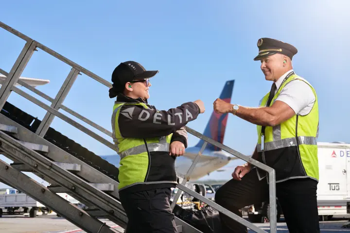 A Delta pilot and ramp employee fist-bump in this 2023 image.