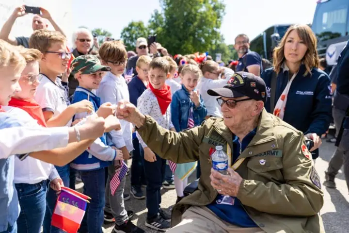 After signing countless autographs, the veterans enjoyed a ride on World War II-era vehicles to Omaha Beach, where they laid roses to remember comrades who lost their lives on those shores.