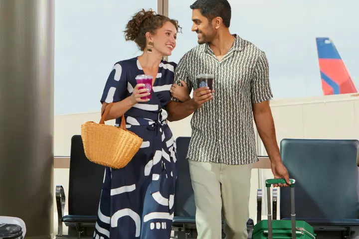 Couple in airport enjoying Starbucks beverages