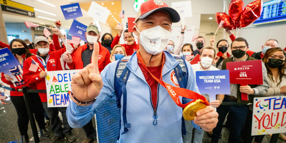 Jen Lee shows his gold medal after returning from the Paralympic Games.