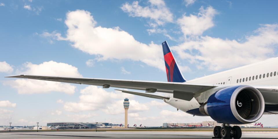 A dorsal view of Delta's Boeing 767-400 model sits on the Atlanta-based runway while a dynamic sky overlooks. 