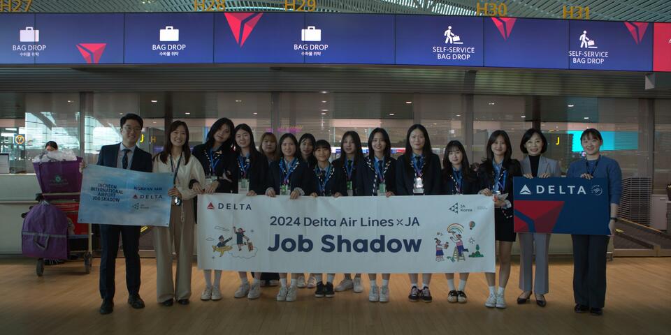 High school students pose in ICN Airport to commemorate their job shadowing experience with Delta and Junior Achievement.