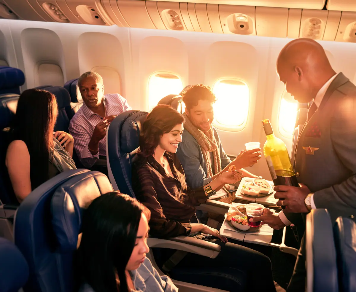 Delta flight attendant with Main Cabin customers.