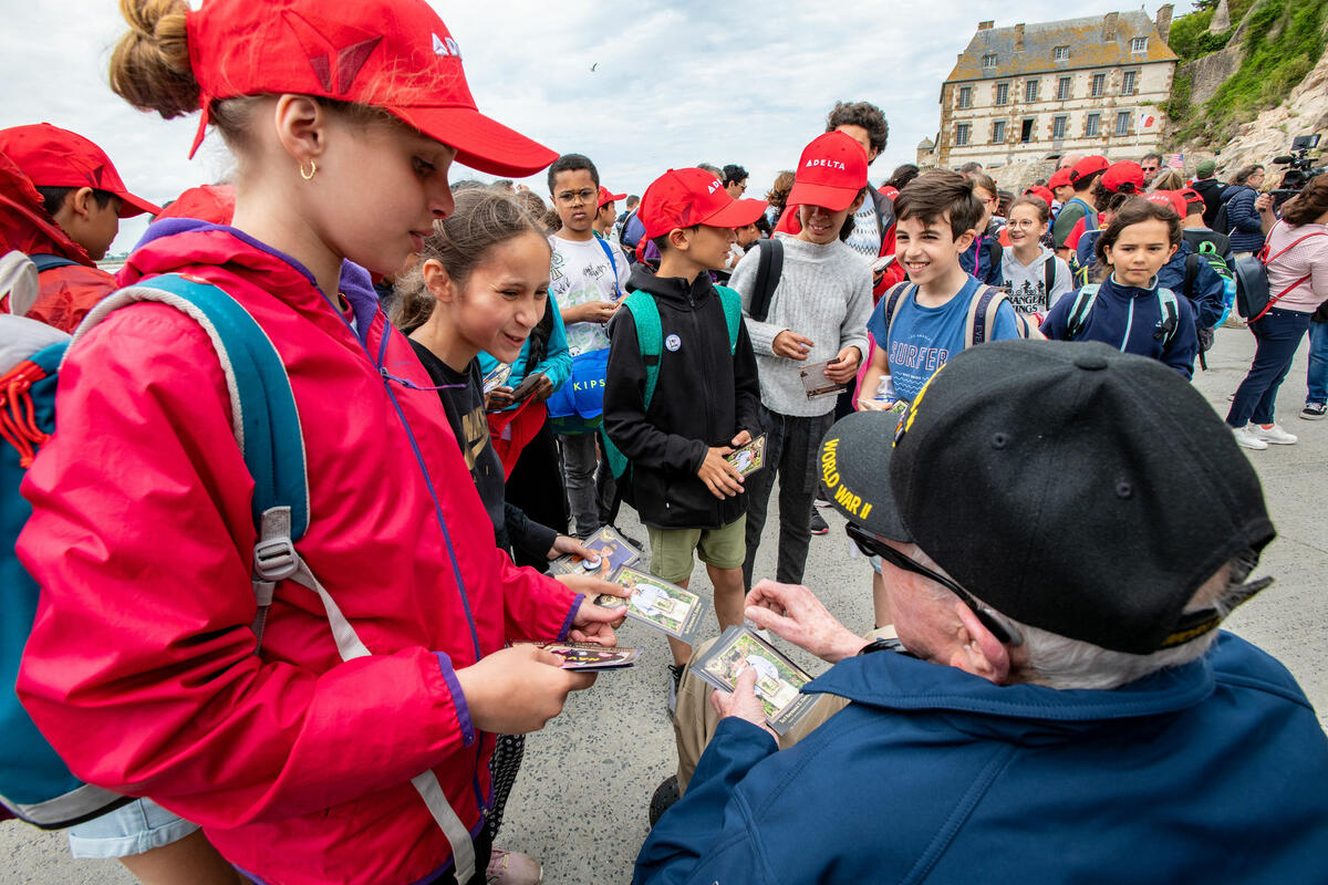 Raymond Dawkins passes his cards out to children at Mont St. Michel.