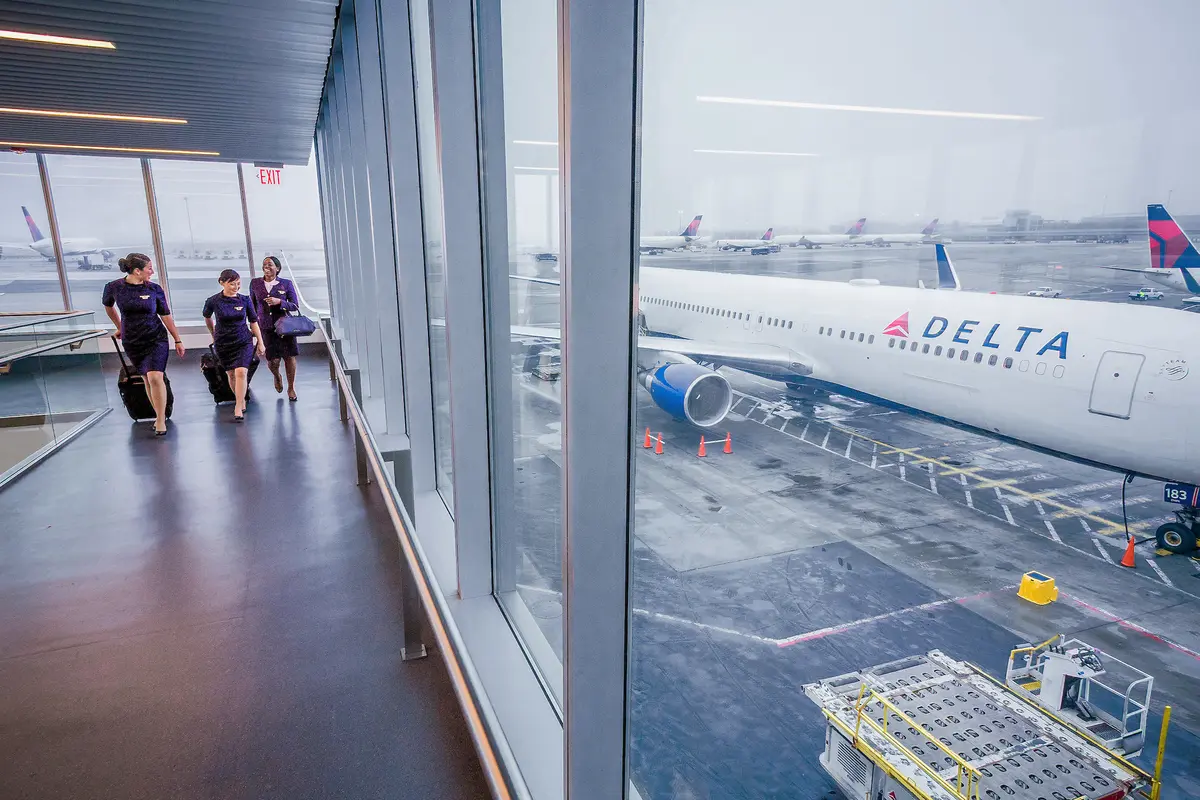 Delta flight attendants walk on a jetway at New York's John F. Kennedy International Airport.