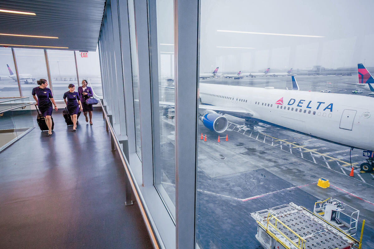 Delta flight attendants walk on a jetway at New York's John F. Kennedy International Airport.