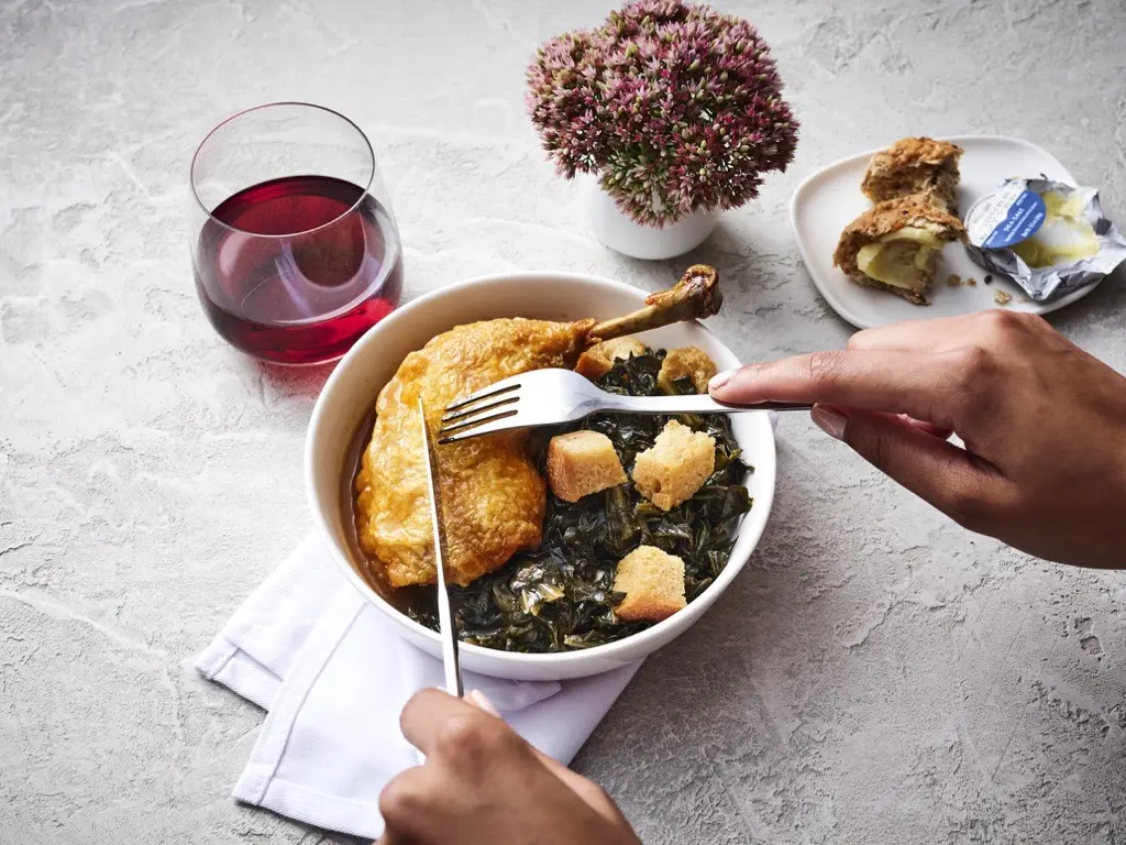 Roasted chicken with smoked collard greens, a Delta first class meal offering, created by Chef Mashama Bailey