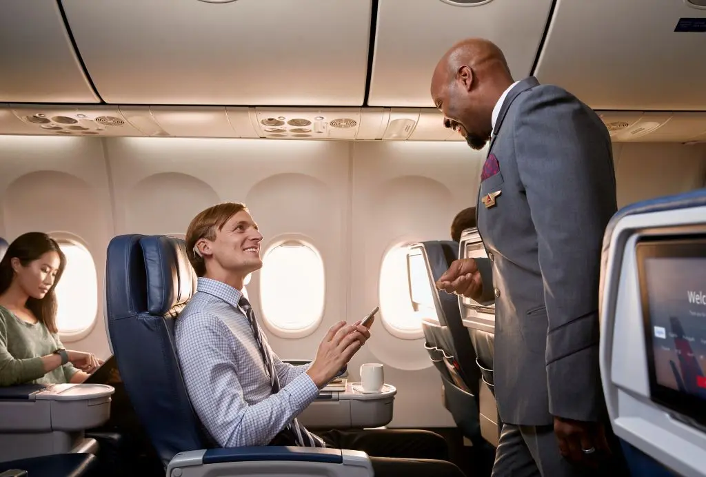 Flight attendant helping customer on board