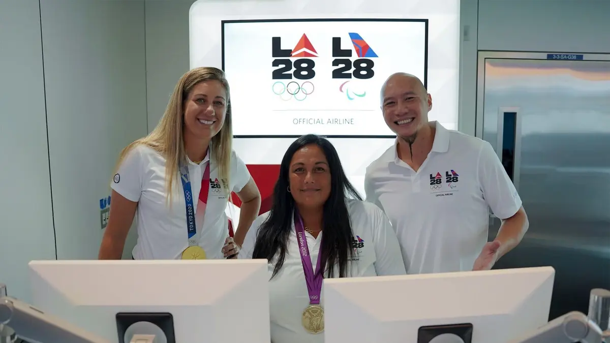 U.S. Olympians April Ross (left) and Brenda Villa (center), and U.S. Paralympian Jen Lee (right) pose for a photo at LAX near Delta's co-created LA28 logo on Sept. 29, 2022.