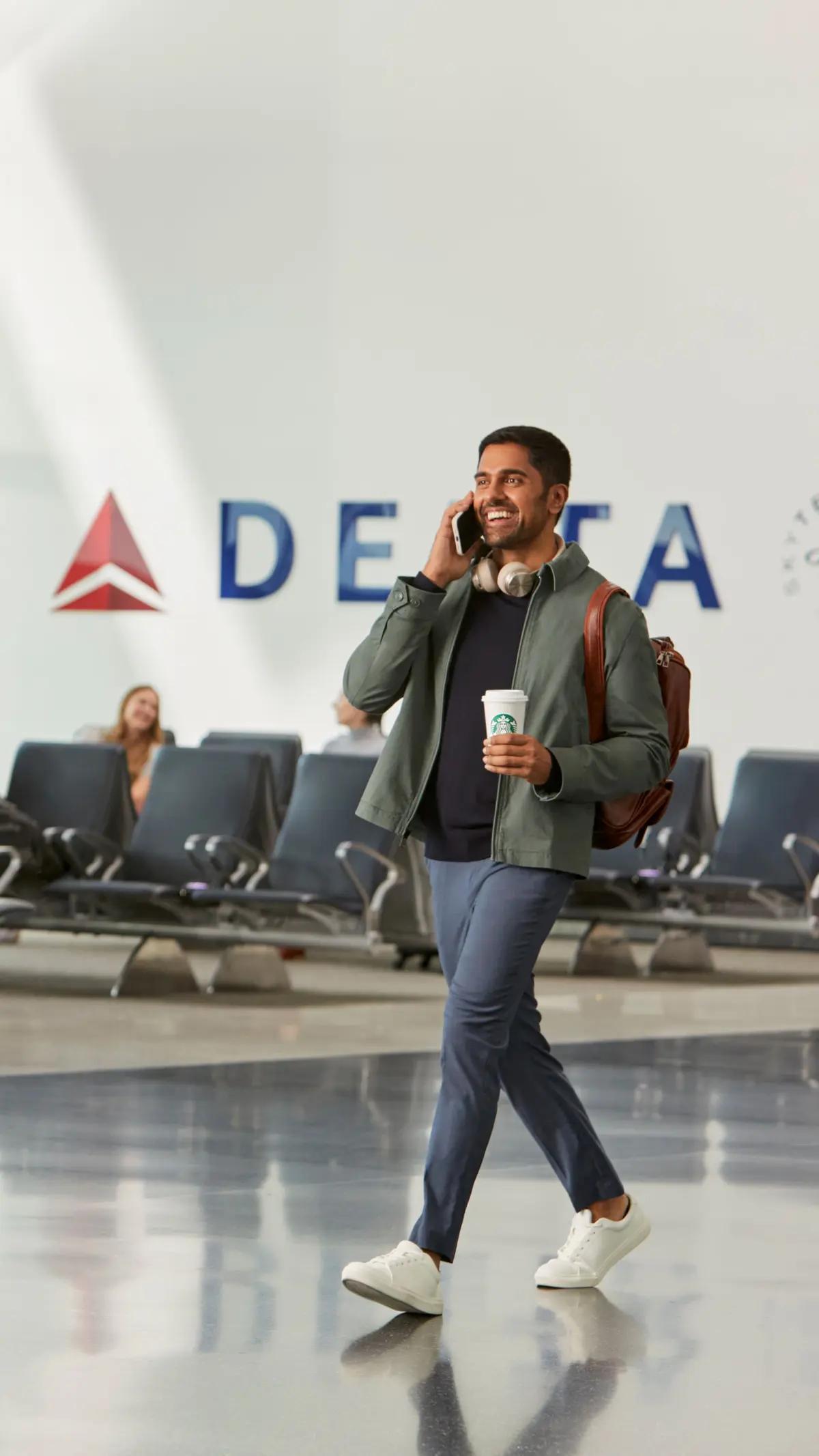 Traveler in airport enjoying Starbucks beverage