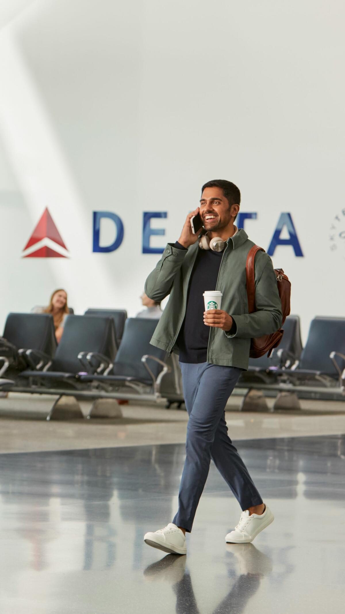 Traveler in airport enjoying Starbucks beverage