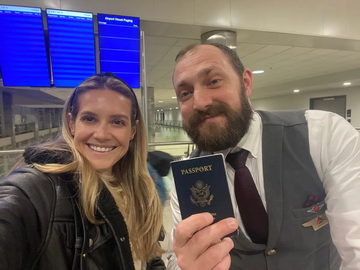 Lawryn Fellwock poses with Delta flight attendant Dusty Dills -- holding the passport she left behind on her honeymoon trip.