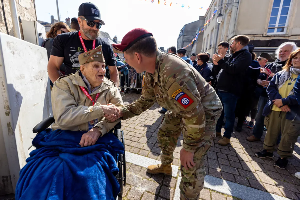 A World War II veteran is greeted by an Army Ranger in Normandy in June 2023.
