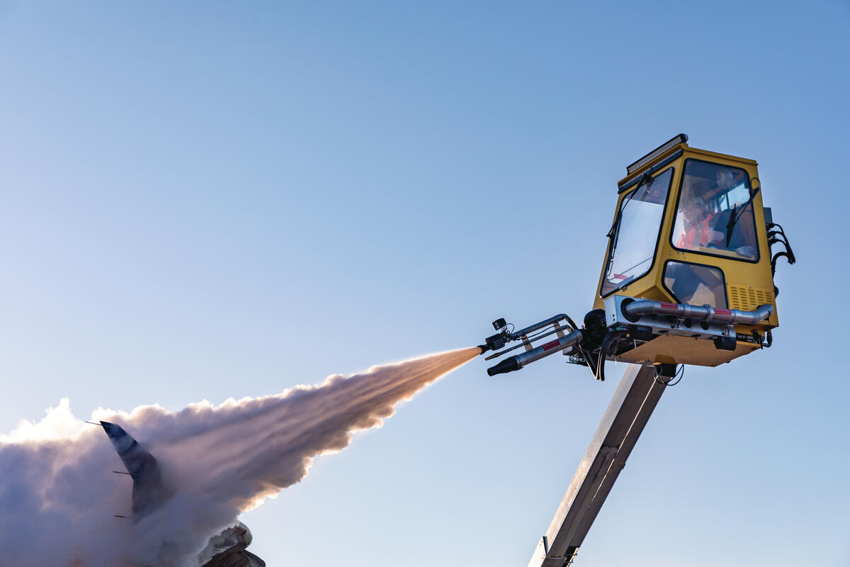 A Delta worker de-ices an airplane at Minneapolis-Saint Paul International Airport.