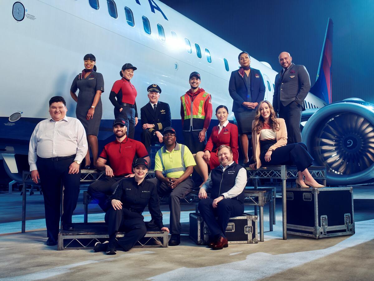 Employees from across Delta's divisions pose in front of a plane in 2023.