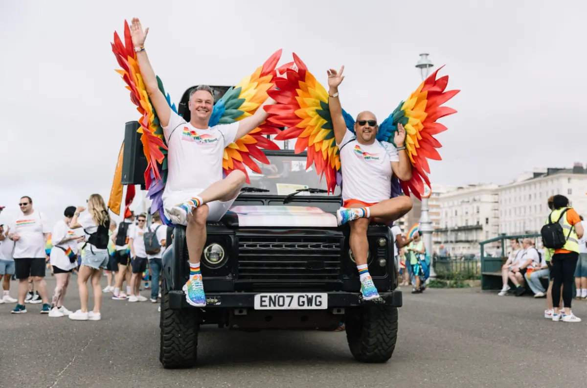 Two people wear rainbow wings for the Brighton & Hove Pride parade