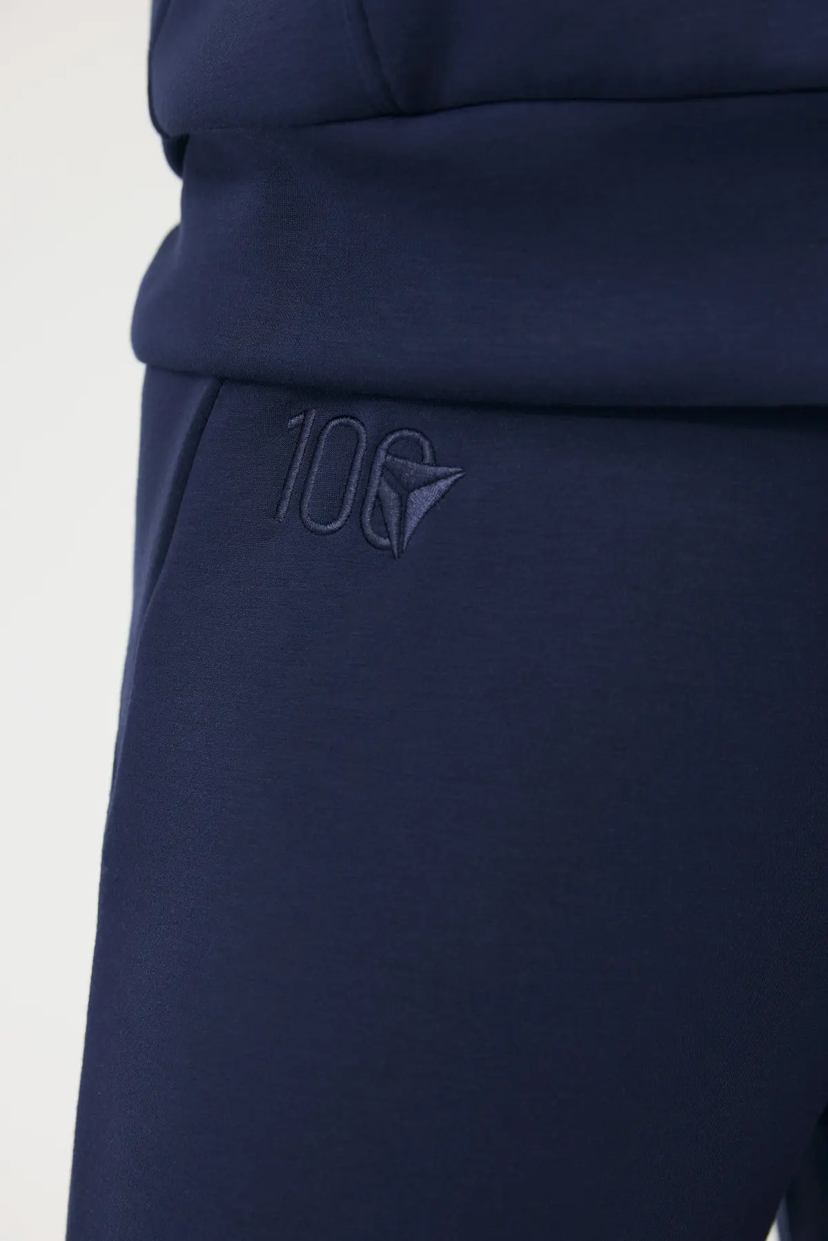 Close up of Delta Centennial logo embroidered on navy wide leg Spanx pants.